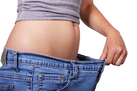 A person showing weight loss by wearing loose jeans, highlighting successful weight reduction. Benefits of Ozempic